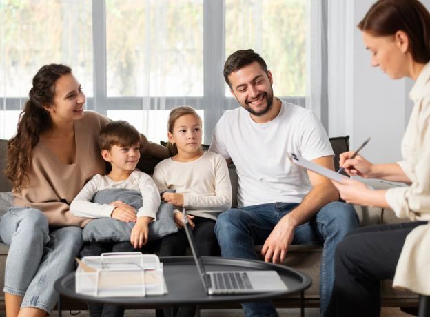 Caring clinician meeting with a young family in a warm office setting, discussing a child's development and evaluation plan